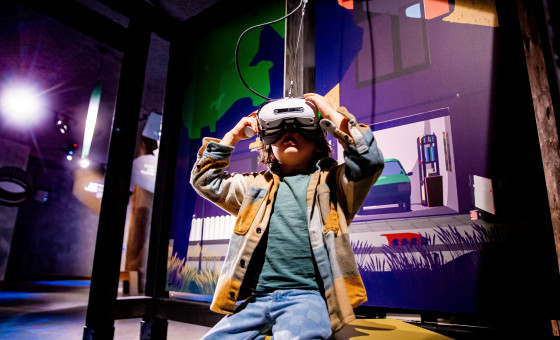 Jonge bezoeker probeert de VR in de tentoonstelling De Grote Reis van Klein Plastic. 