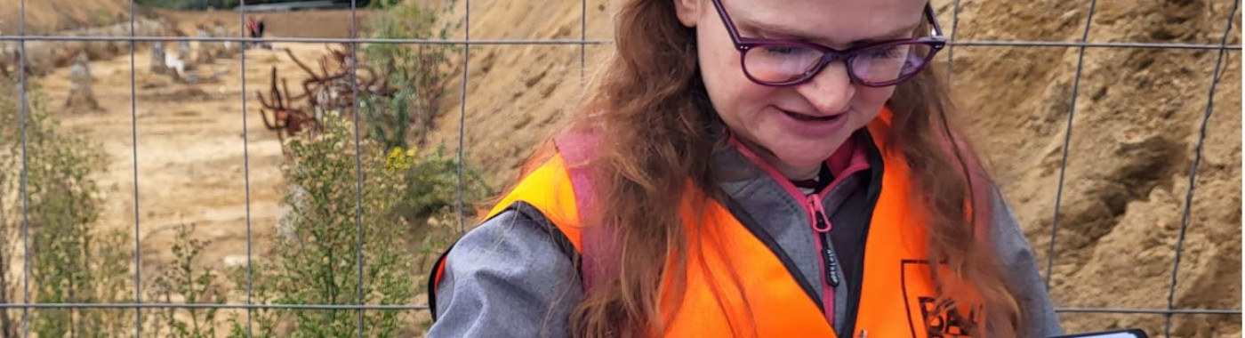 Archeoloog Ester met een boek vol plaatjes van archeologische vondsten