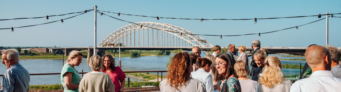 Vergaderen met uitzicht op de Waal en de iconische bruggen van Nijmegen.