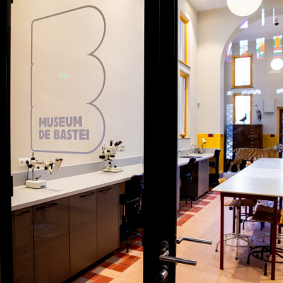 Atelier in het collectiedepot gezien door de glazen entreedeuren.