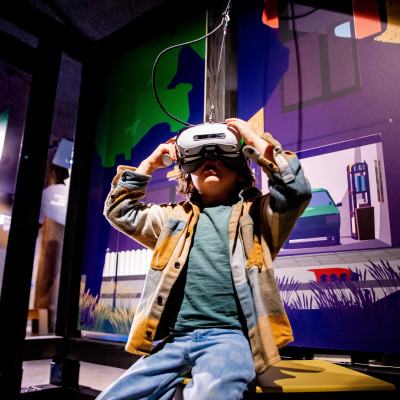 Jonge bezoeker probeert de VR in de tentoonstelling De Grote Reis van Klein Plastic. 